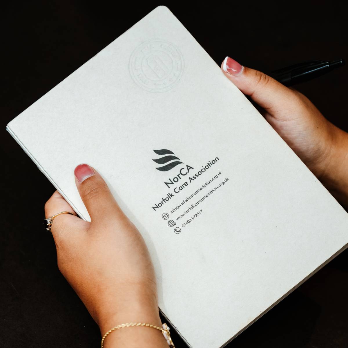 A Norfolk Care Association notebook being held